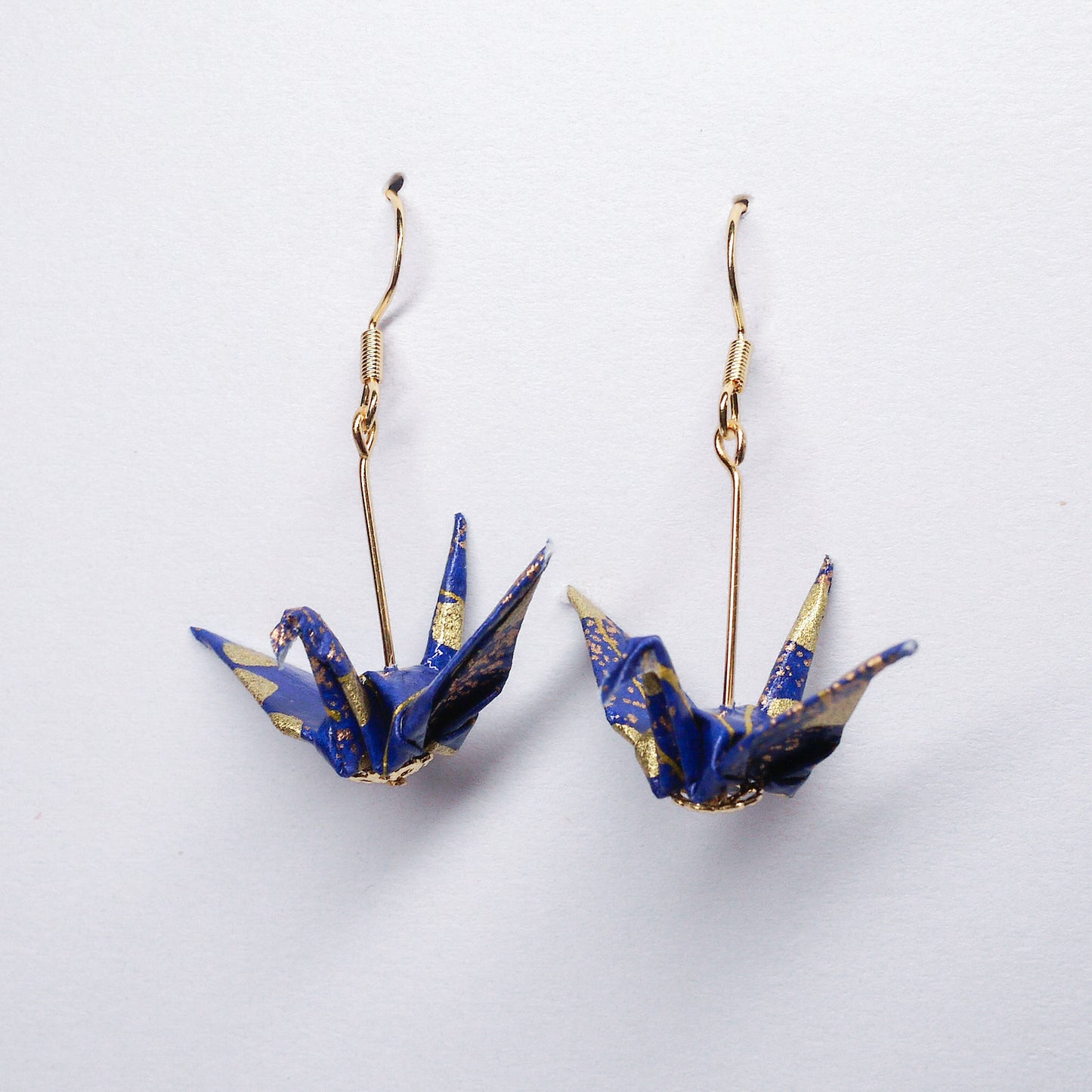 Pair of handmade royal blue origami crane earrings with gold cloud, crafted from traditional Japanese washi paper. front view