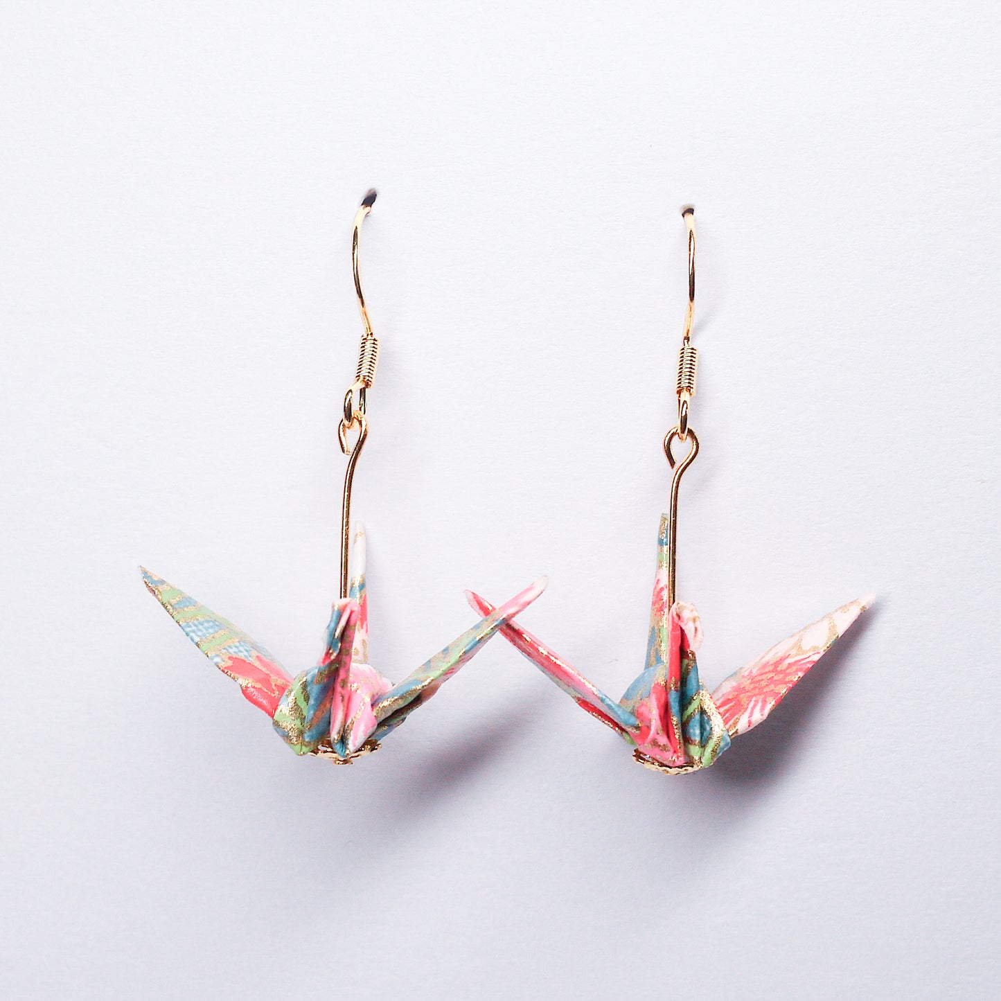 Pair of handmade blue origami crane earrings with pink flowers and hooks, crafted from traditional Japanese washi paper. front view