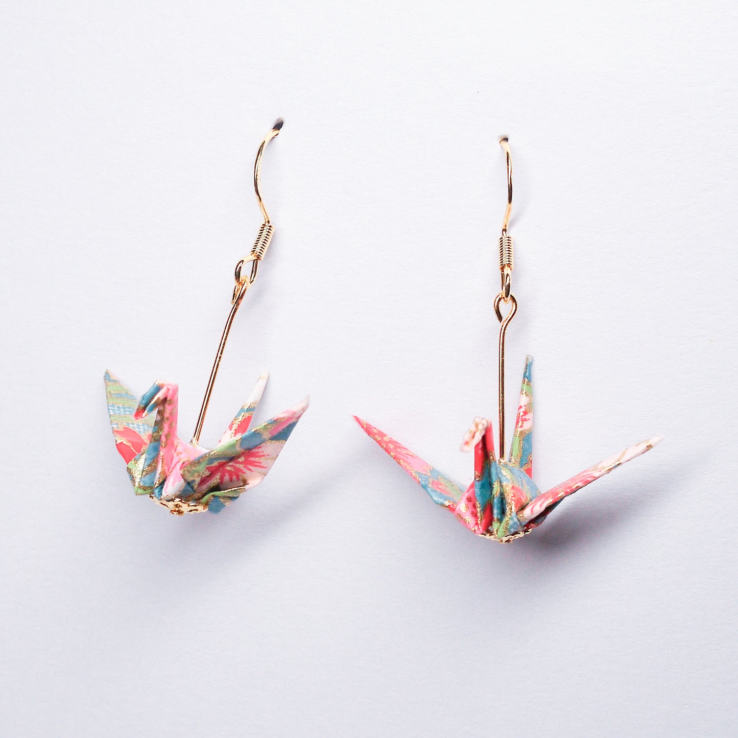 Pair of handmade blue origami crane earrings with pink flowers and hooks, crafted from traditional Japanese washi paper. side view