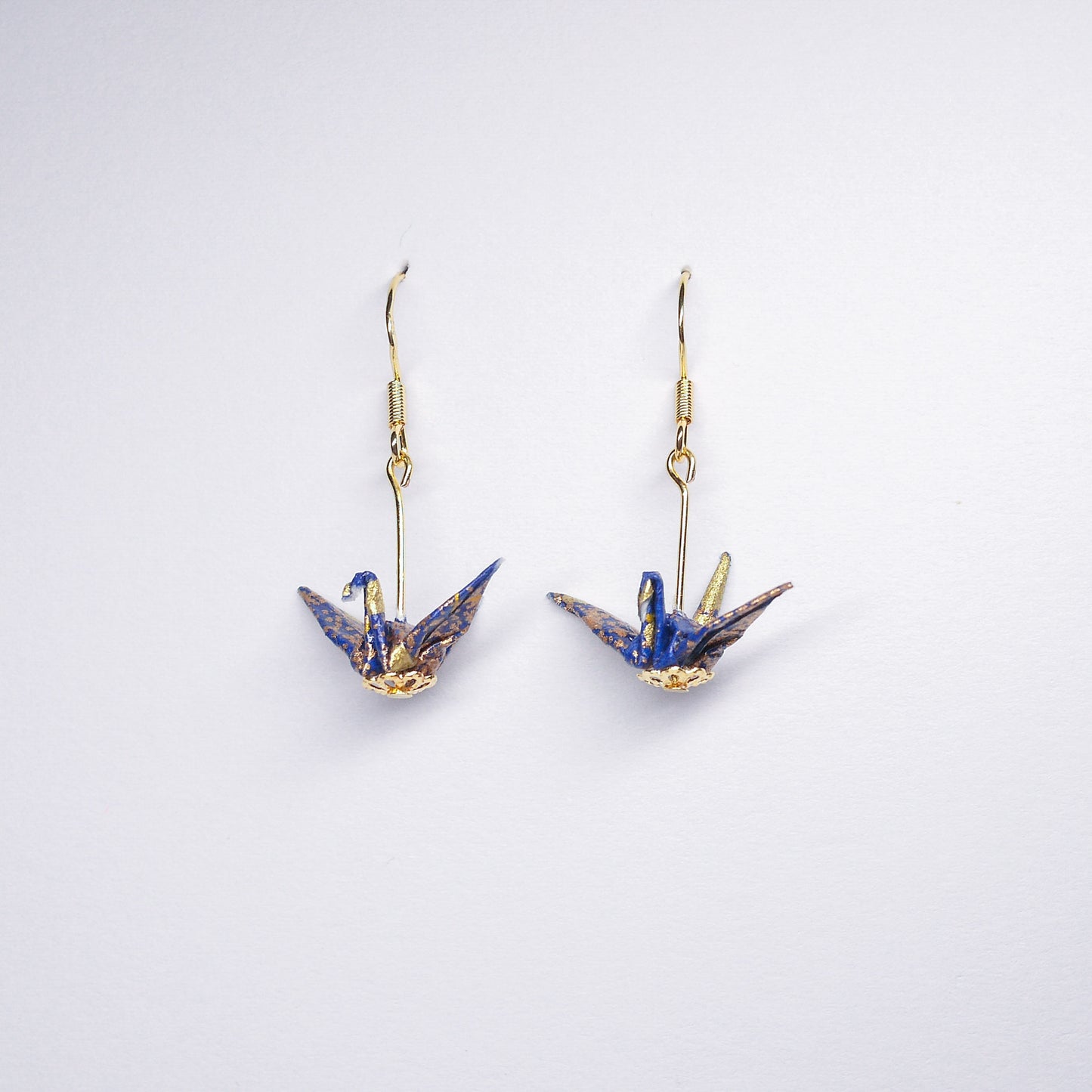 Pair of handmade blue origami crane earrings with gold accents and hooks, crafted from traditional Japanese washi paper.