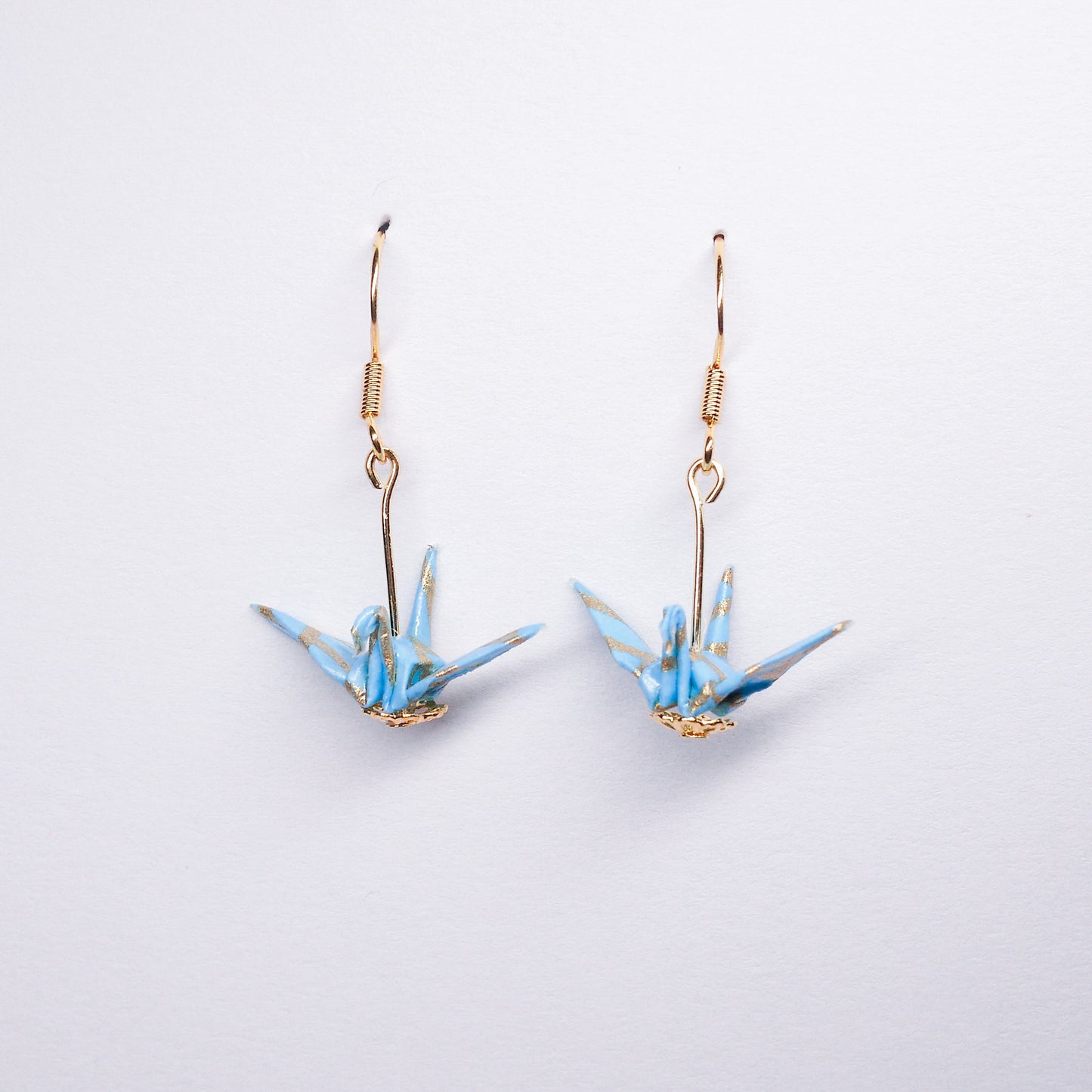 Pair of handmade teal origami crane earrings with gold waves and hooks, crafted from traditional Japanese washi paper. front view