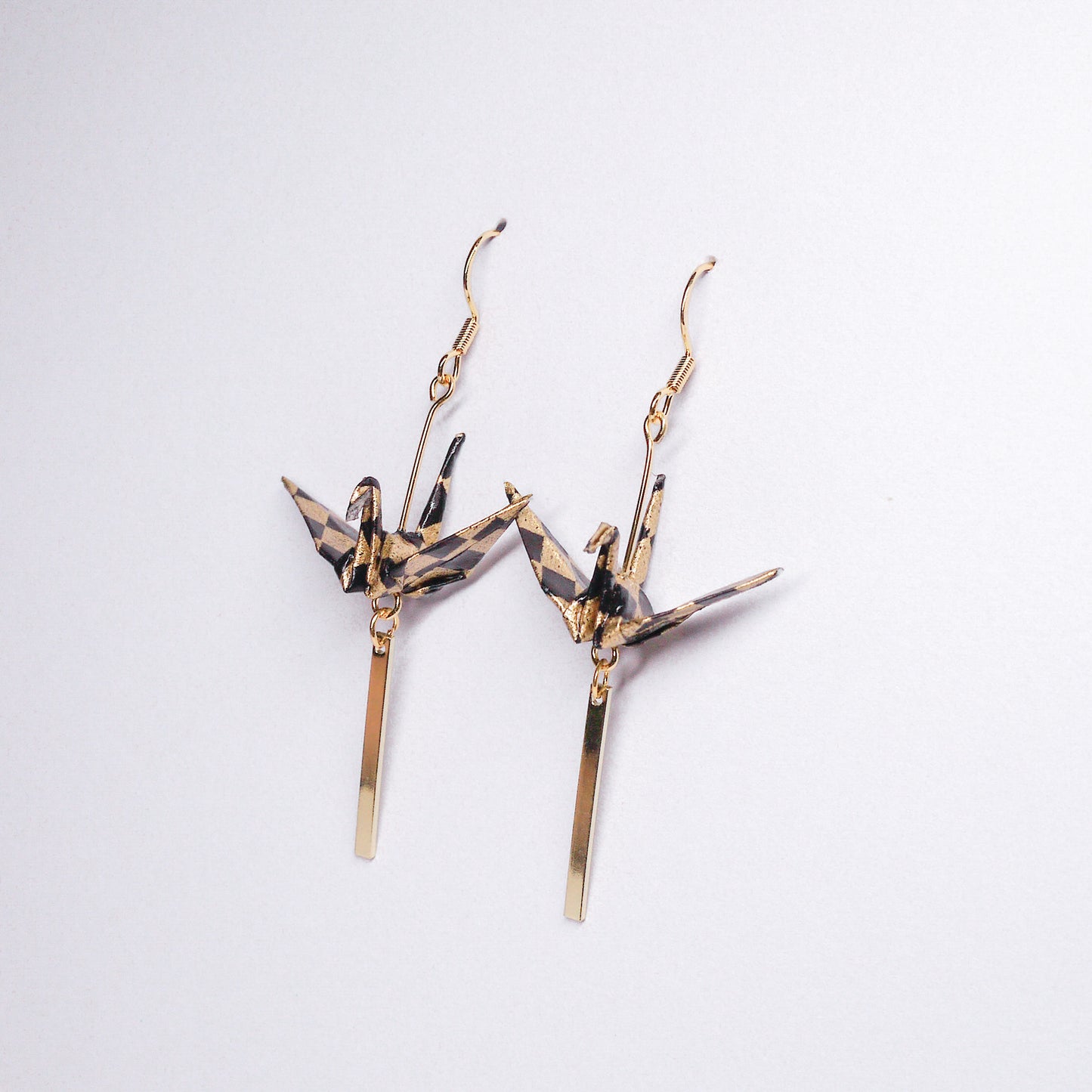 Pair of handmade black origami crane earrings with gold bar and hooks, crafted from traditional Japanese washi paper