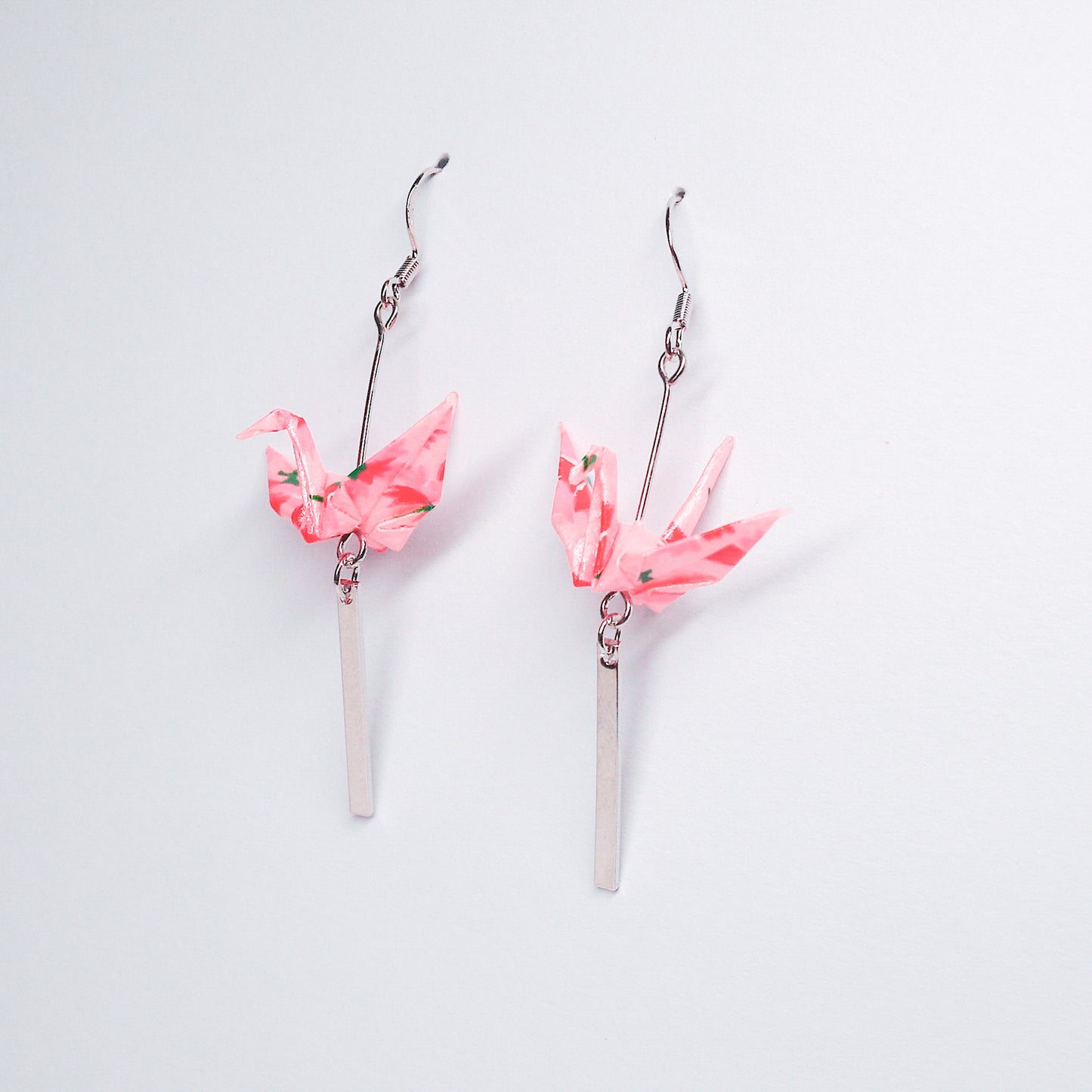 Pair of handmade pink origami crane earrings with silver bar accents and hooks, crafted from traditional Japanese washi paper