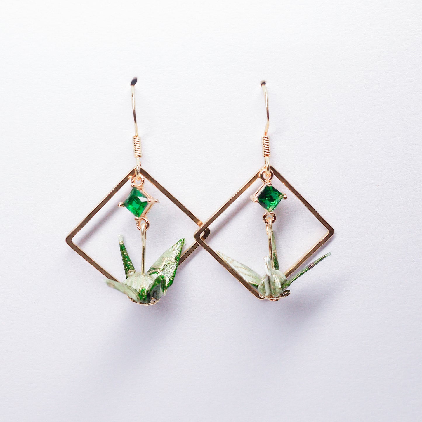 Pair of handmade green origami crane earrings with gold square hoops and sparkling zircon accents, crafted from traditional Japanese washi paper.