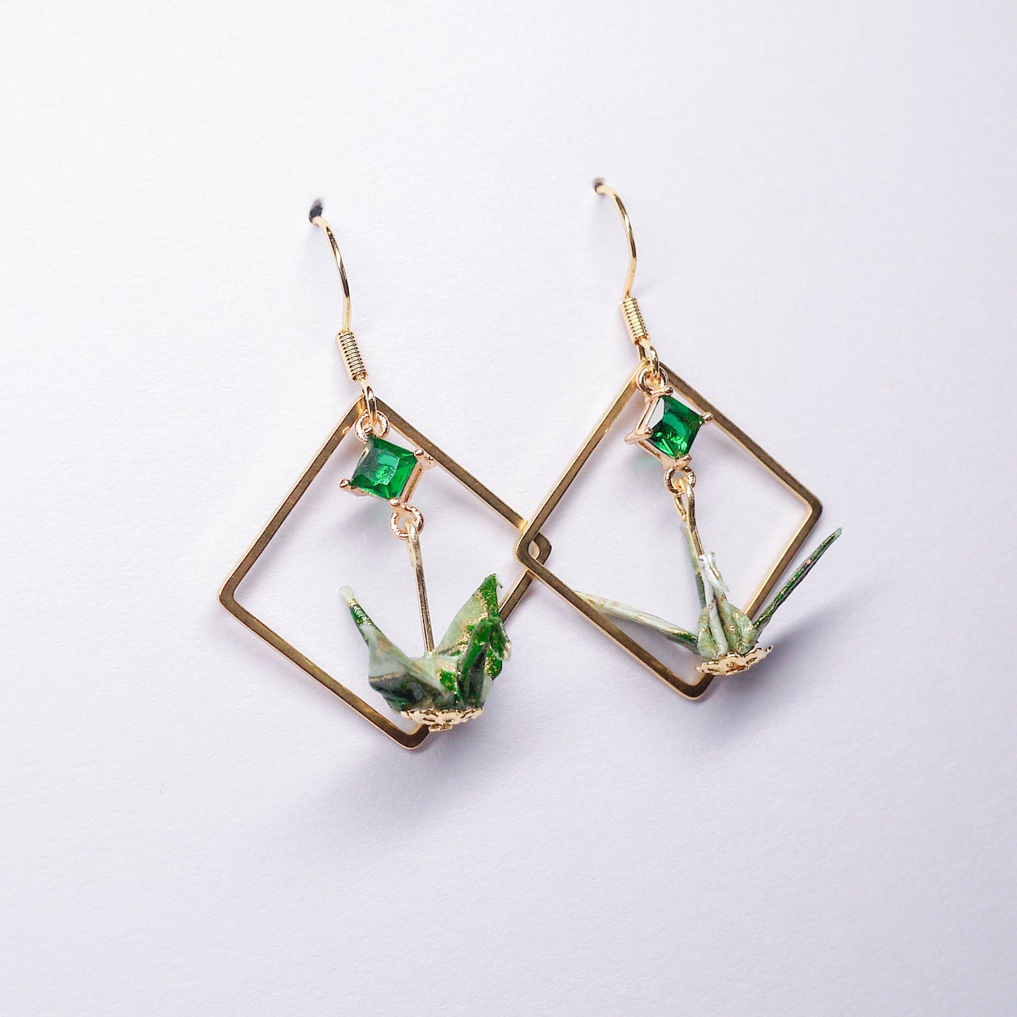 Pair of handmade green origami crane earrings with gold square hoops and sparkling zircon accents, crafted from traditional Japanese washi paper.