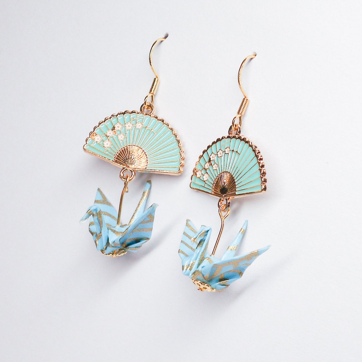 Pair of handmade teal origami crane earrings with gold fan charms and hooks, crafted from traditional Japanese washi paper