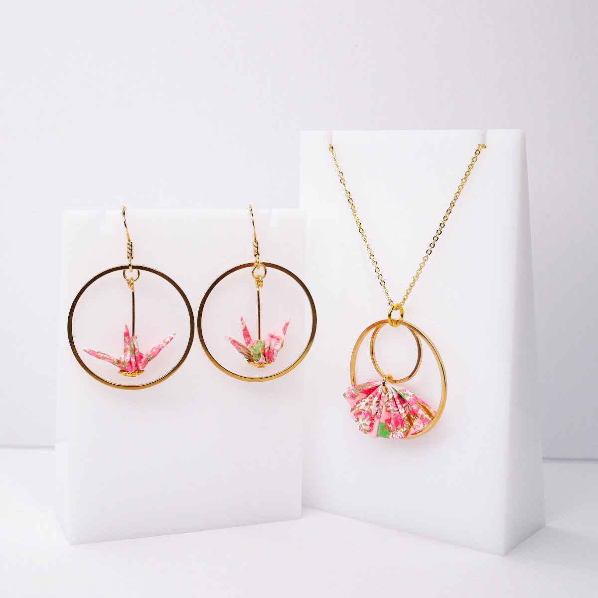 Jewelry set with pink floral elements on a white background