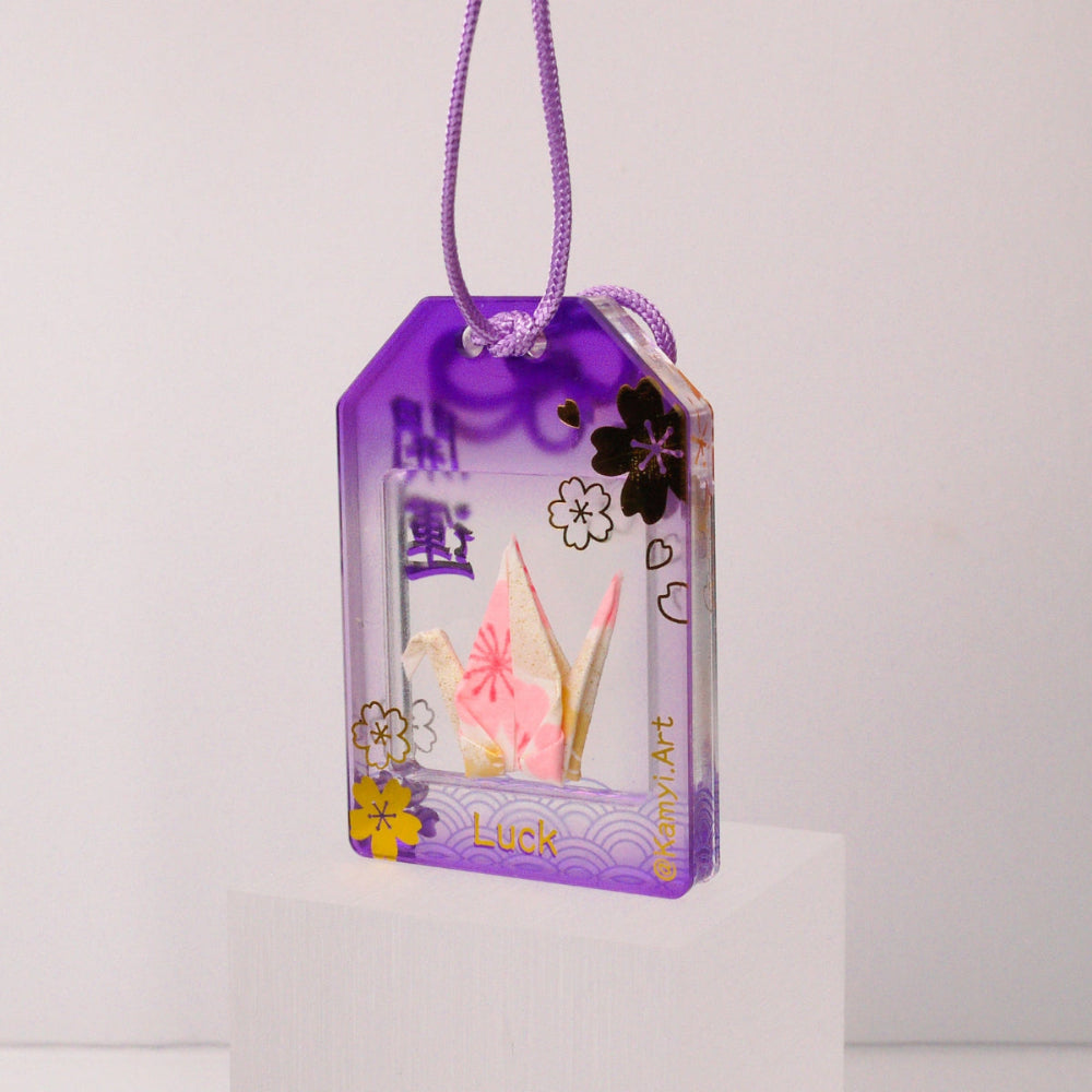 Small crane in a purple transparent box with floral designs on a white background